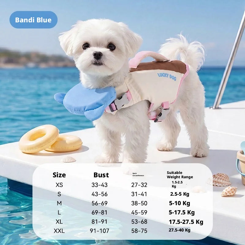 A small white dog on a boat wearing a life jacket, with a size chart overlay at the bottom showing sizes, weights, and measurements. The life jacket is labeled 'Bandi Blue' and features a blue whale-shaped front panel.