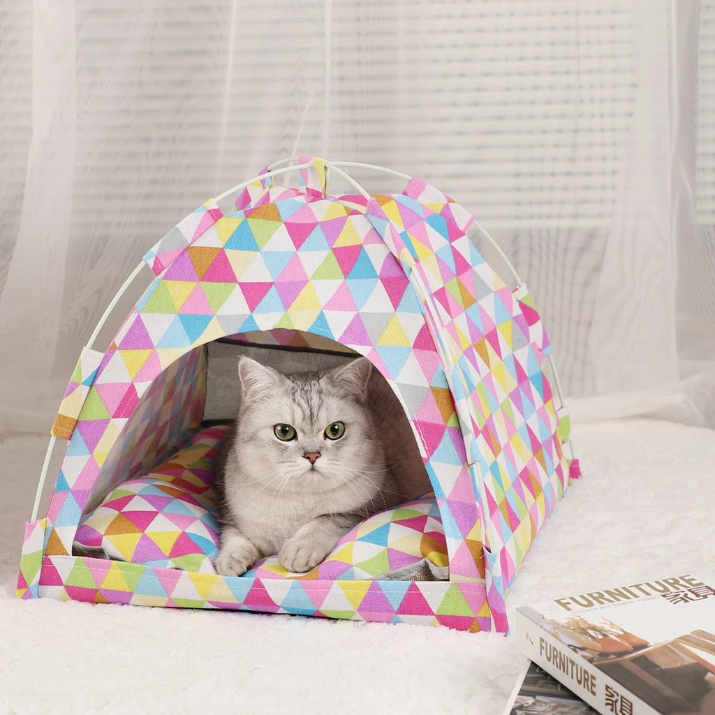 Cat inside a colorful geometric-patterned pet tent on a light background