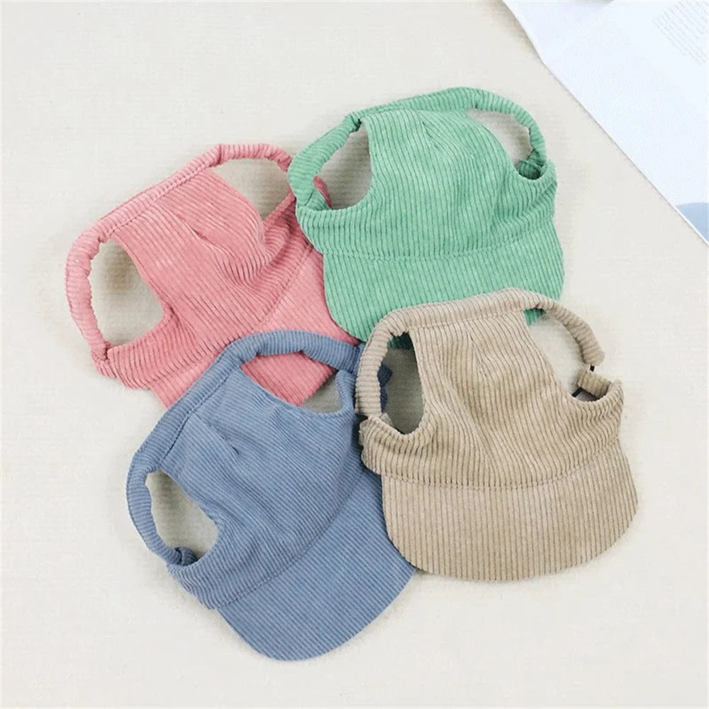 Four colorful baby bibs in pink, green, blue, and beige on a light background.