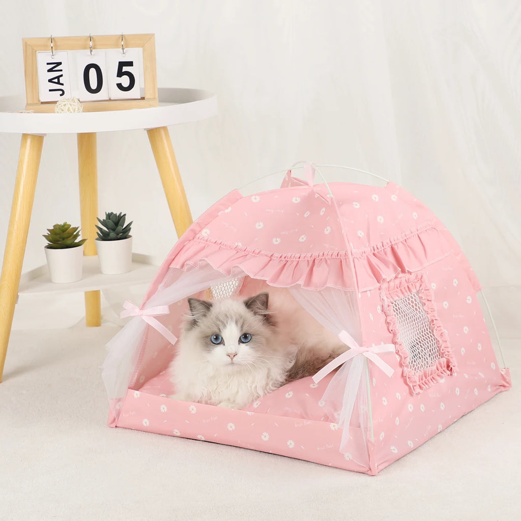 Cat lying inside a pink polka dot pet tent on a light-colored floor.