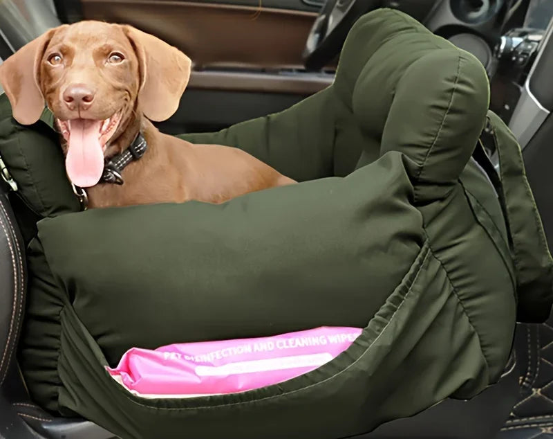 Dog in a green car seat cover with a pink cooling pad inside a vehicle.