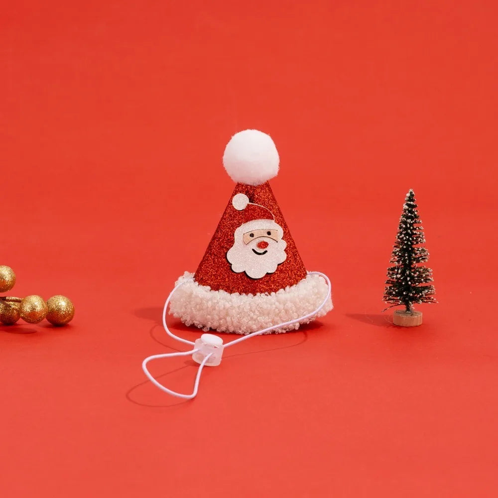 A festive red glitter Santa hat with white faux fur trim, a white pom-pom, and a white elastic ear loop attached. The hat features a printed white Santa face.