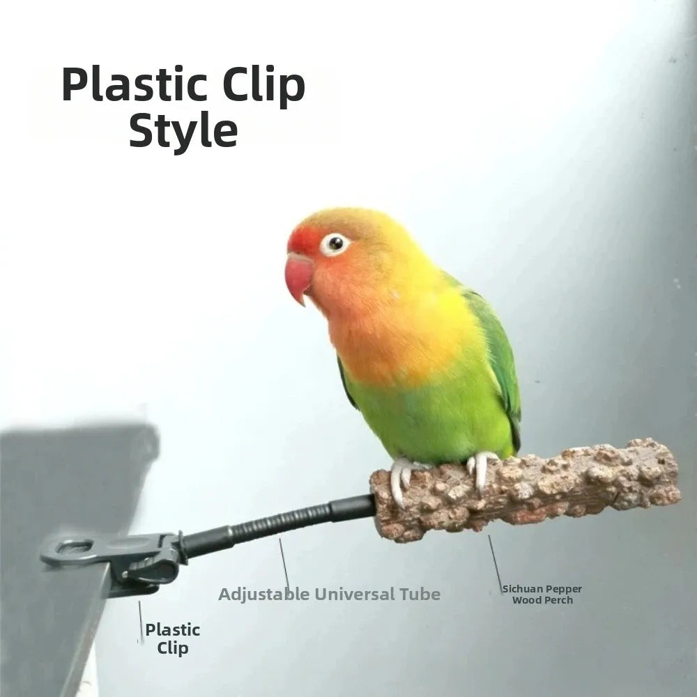 A lovebird perched on a branch attached to a black adjustable plastic clip, with text labels reading 'Plastic Clip Style,' 'Plastic Clip,' 'Adjustable Universal Tube,' and 'Sichuan Pepper Wood Perch' on a plain light background.