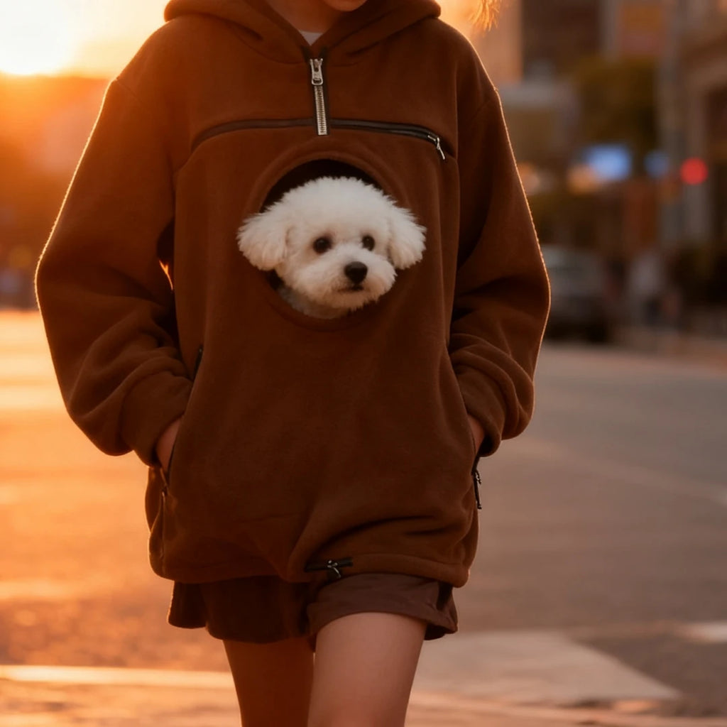 Person wearing a brown hoodie with a dog's face on it, standing outdoors during sunset.