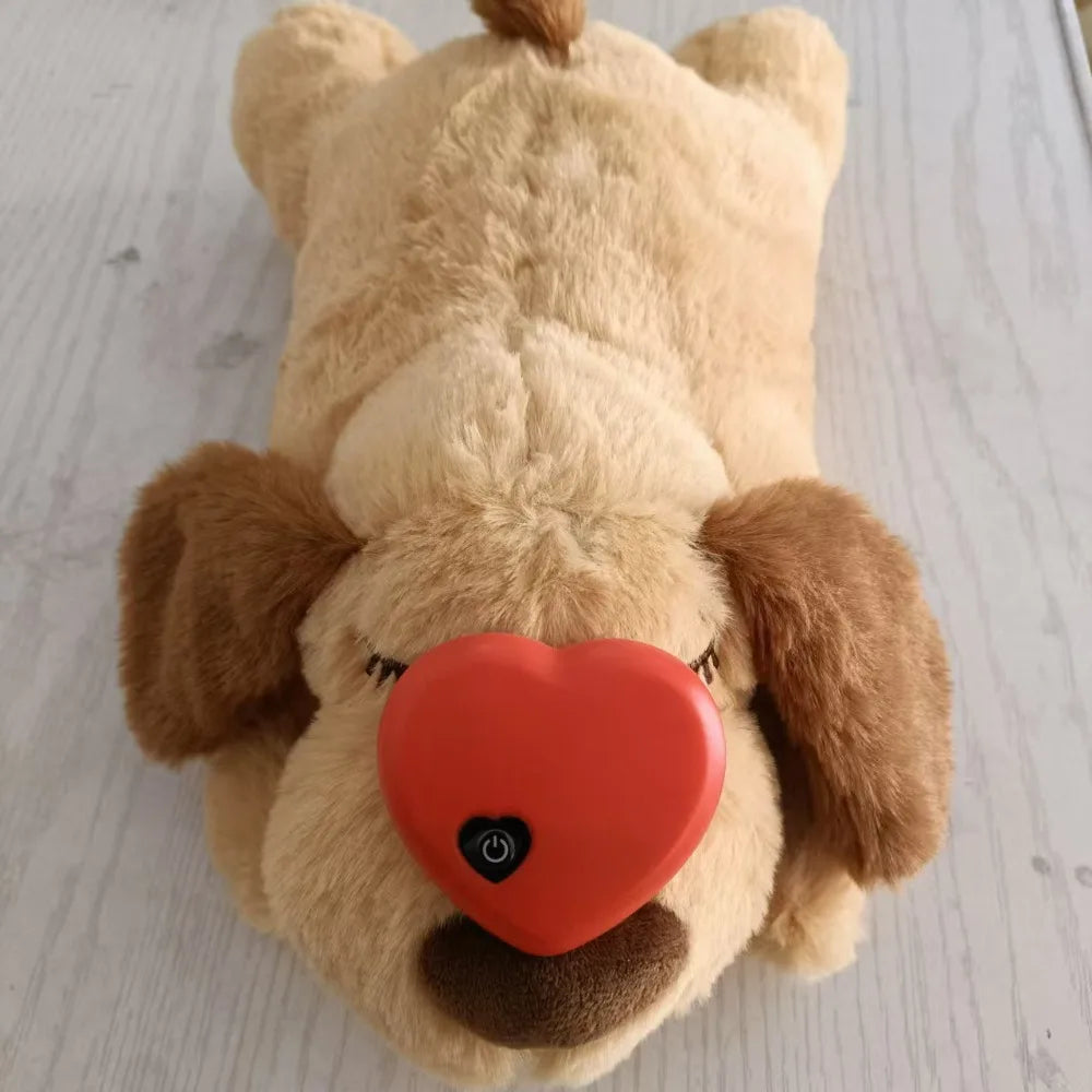 Plush dog toy with a red heart-shaped nose on a light wooden floor.