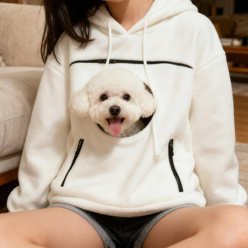 Person wearing a white hoodie with a dog design on it, sitting on a couch.