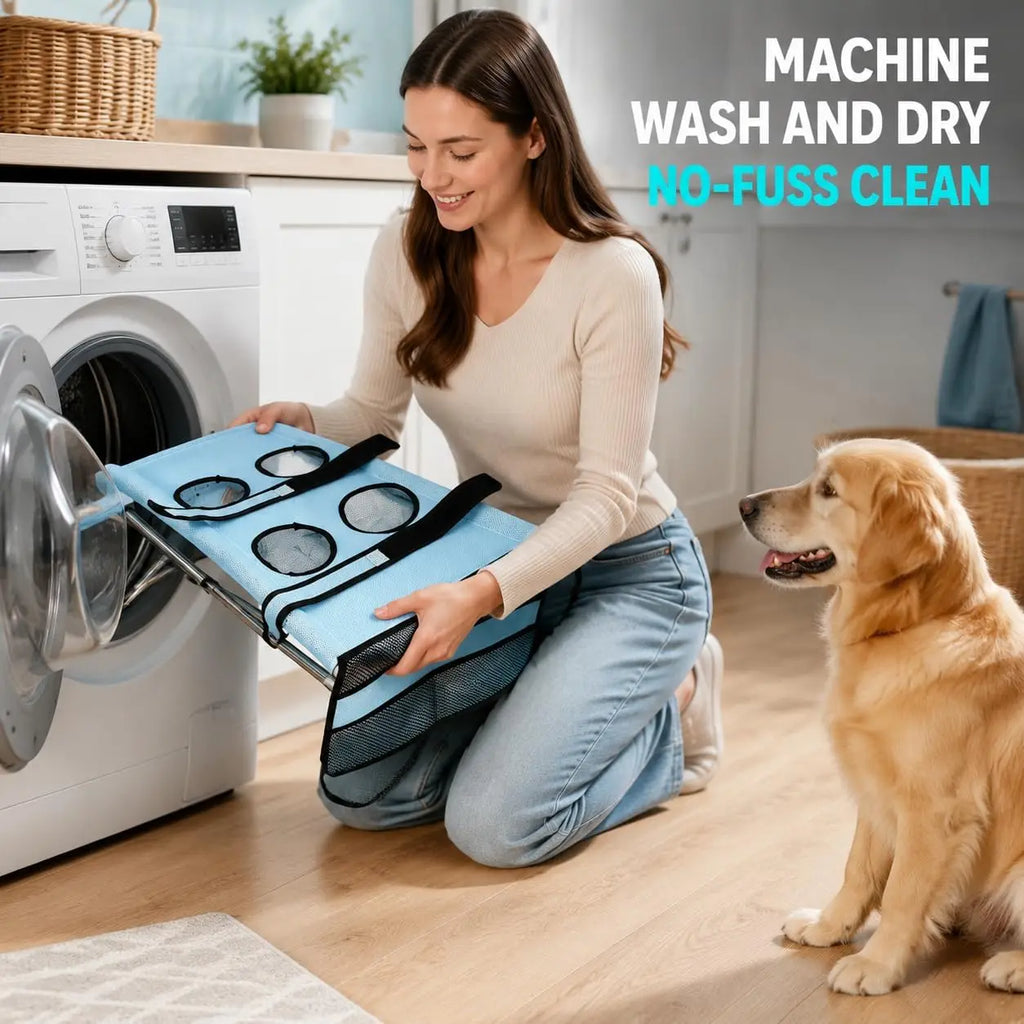 A woman kneels beside a washing machine in a bright laundry room, holding a blue pet laundry transfer bag with circular mesh pockets. A golden retriever sits nearby, and the text reads 'MACHINE WASH AND DRY NO-FUSS CLEAN'.