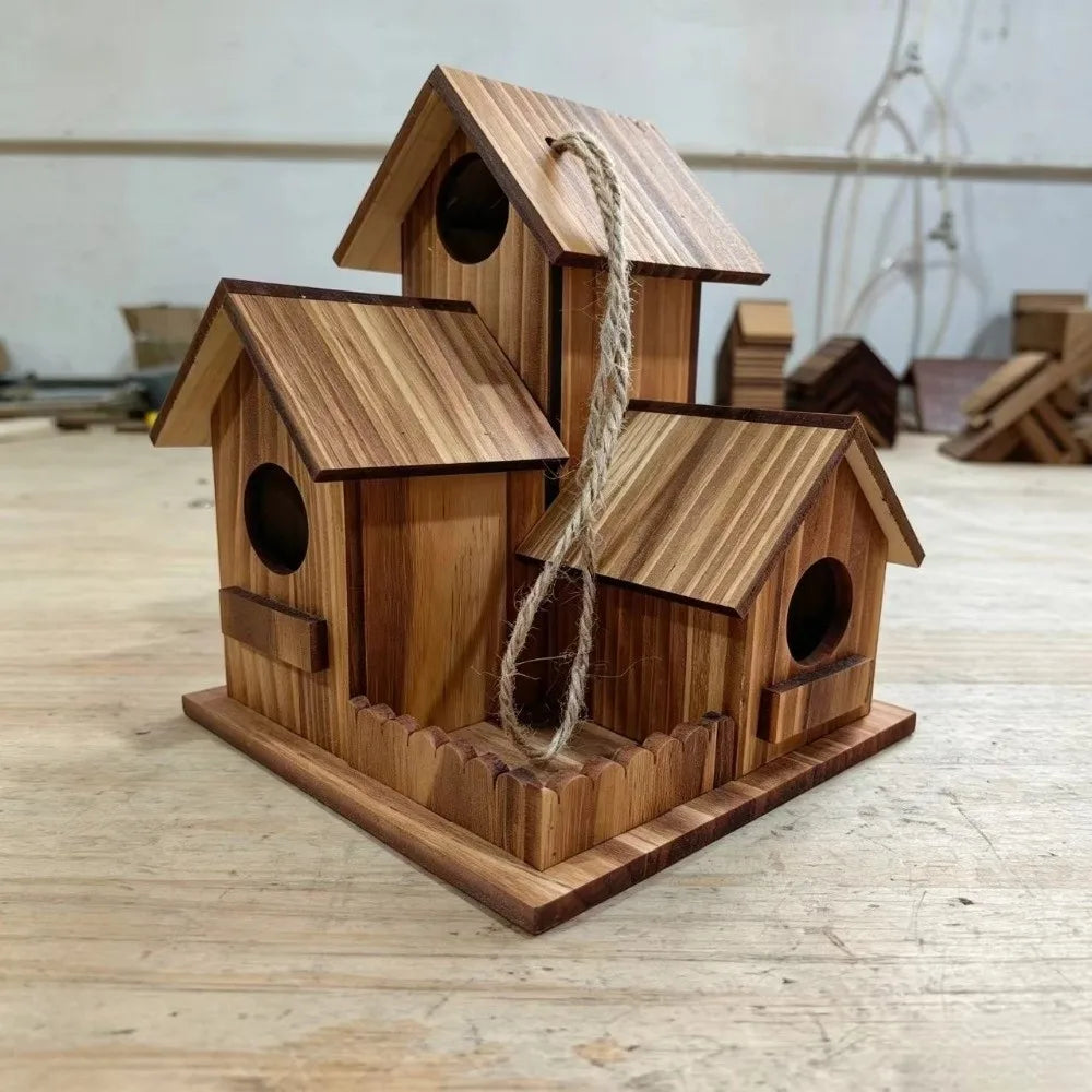 Three wooden birdhouses stacked on a wooden surface with a blurred background.