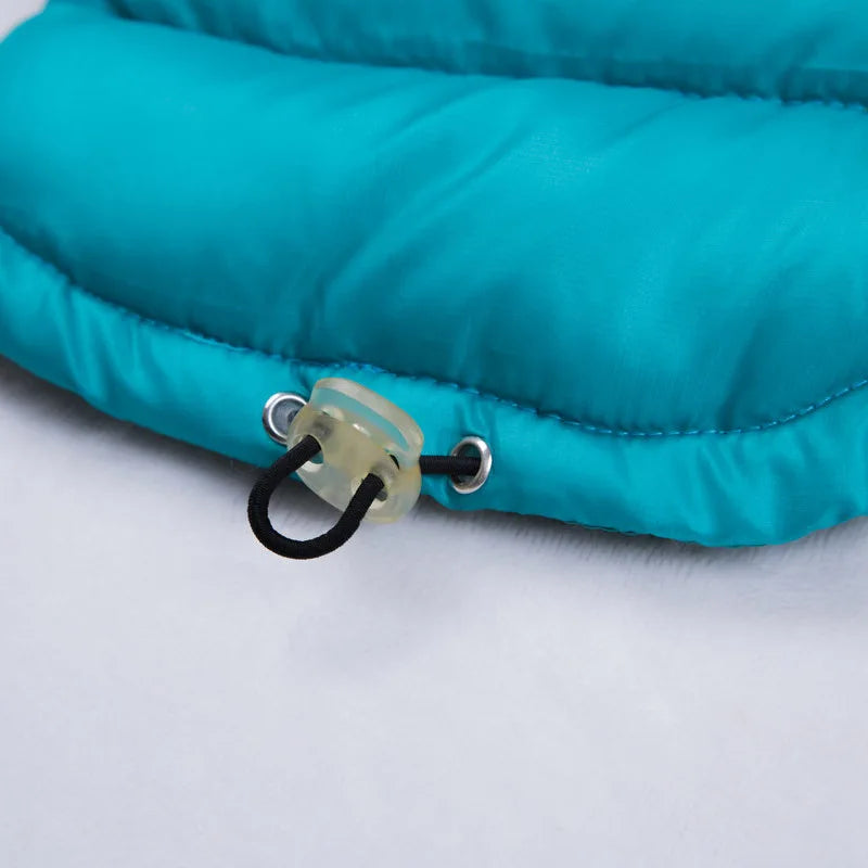Close-up of a teal inflatable pillow with a black strap and green valve on a white background