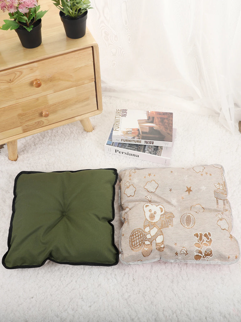 Green pillow and patterned blanket on a bed with a wooden nightstand and plants in the background.