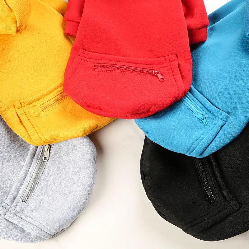 Five colorful beanies with zippers in yellow, red, blue, gray, and black on a light background.