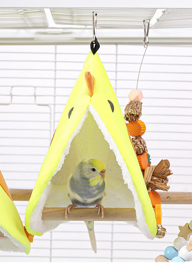 Bird perched inside a yellow birdhouse with a wooden perch on a white background
