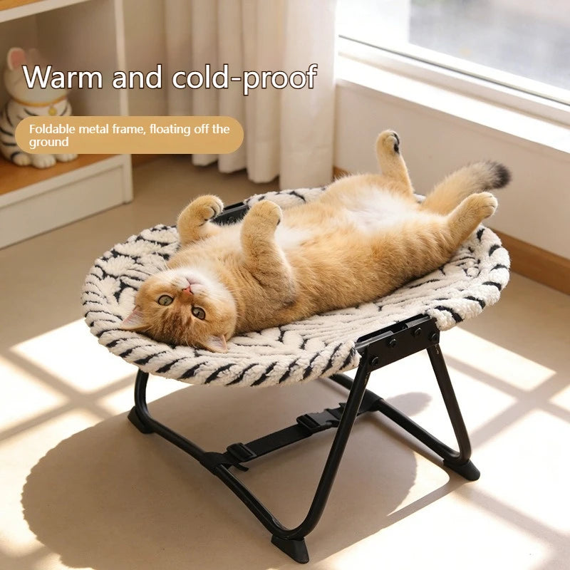 Cat lying on a small pet bed with text 'Warm and cold-proof' in a bright room.
