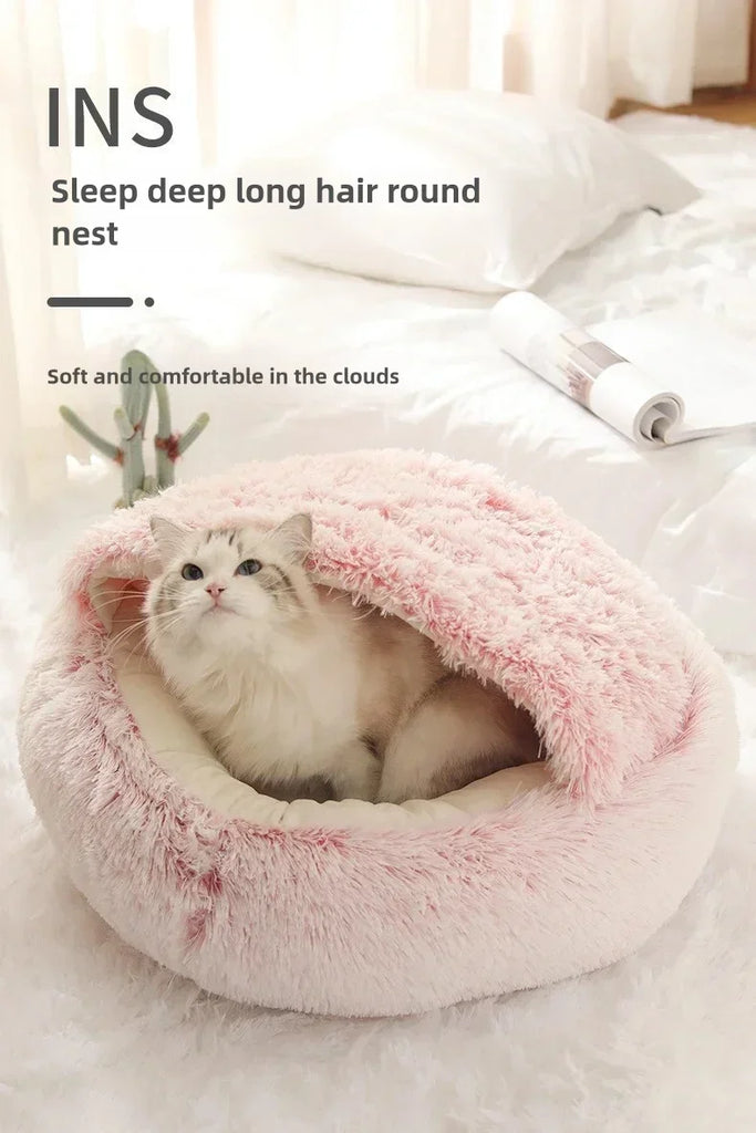 Cat lying in a pink plush pet bed on a soft surface with text describing the product.
