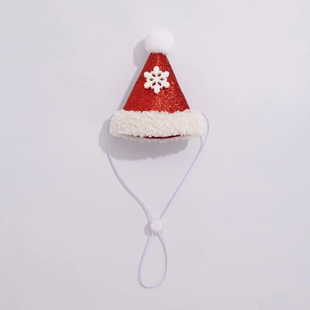 A festive red Santa hat face mask with white faux fur trim, a white pom-pom, and a white snowflake ornament on the front. A thin white elastic strap with a sliding button closure hangs below the hat, set against a plain white background.