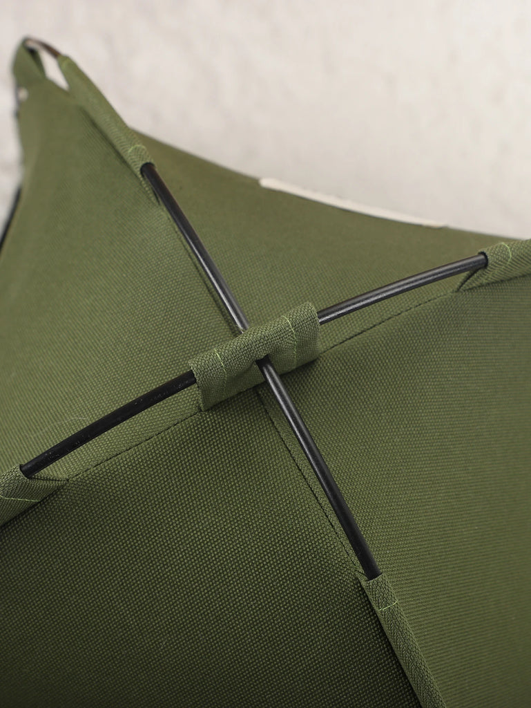 Close-up of a green umbrella with black ribs against a white background