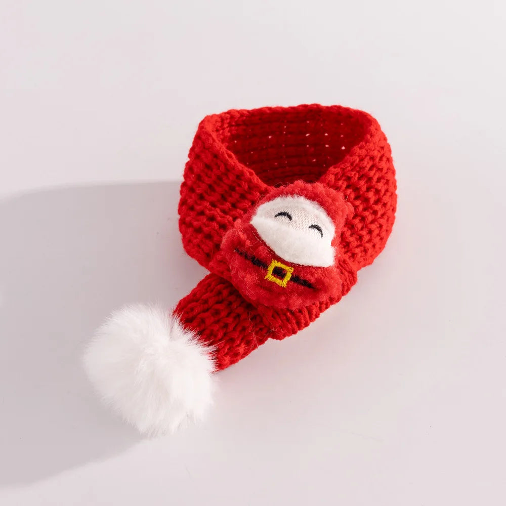A red knitted Santa hat with a white faux-fur pom-pom and a white embroidered Santa face on the front, photographed on a clean white background.