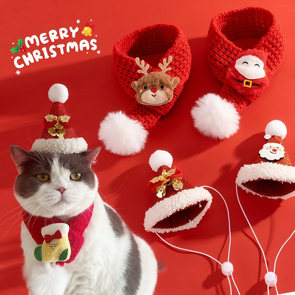 A cat wearing a red knit Christmas hat and scarf sits beside several matching red pet accessories on a red background, including booties with reindeer and Santa faces, a bell-shaped hat, and Santa face ear muffs. The word 'MERRY CHRISTMAS' appears in the top left.