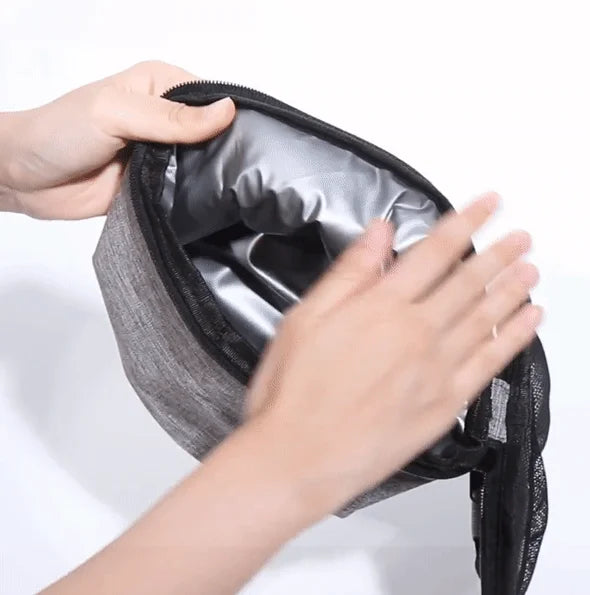Person opening a gray insulated lunch bag with a white background