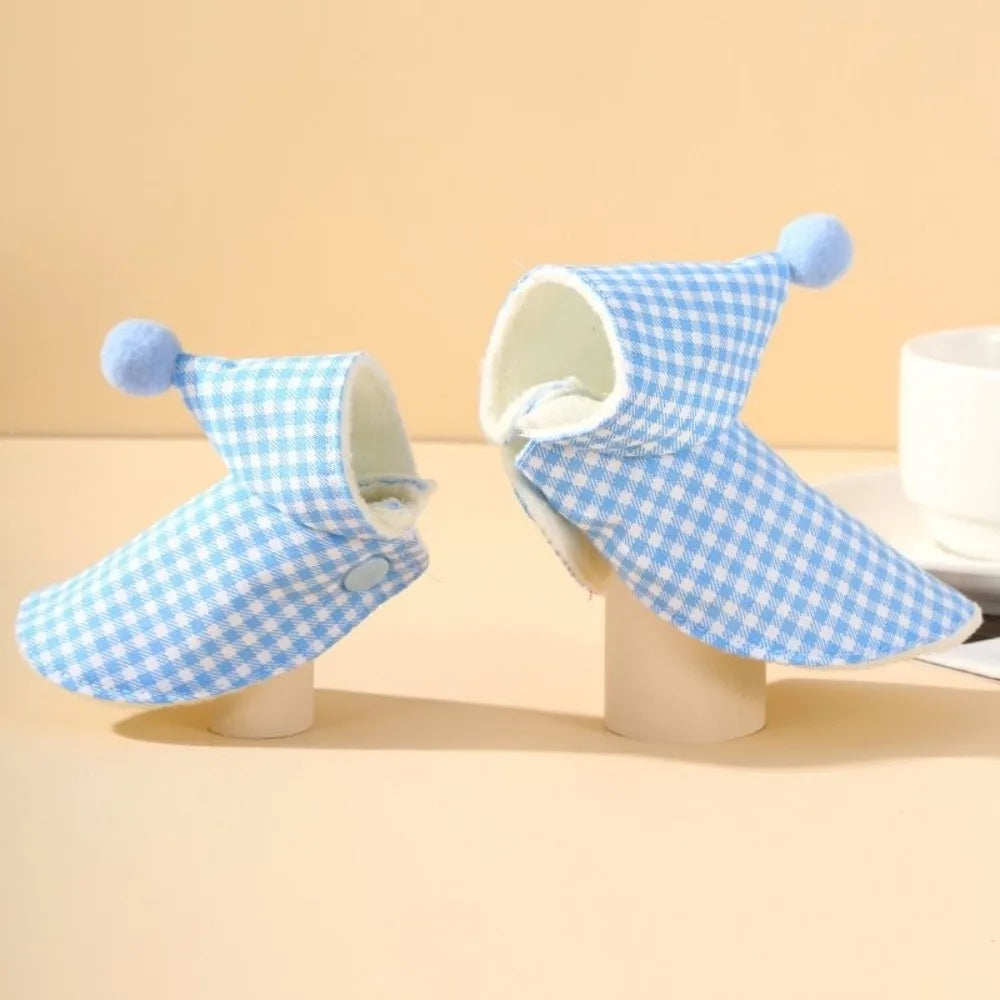 Blue checkered pet raincoat on mannequin against a beige background