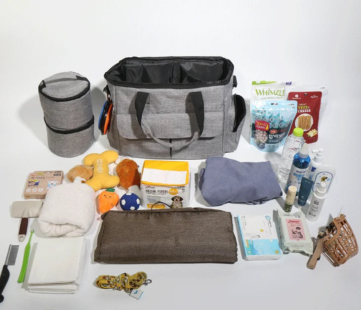 Gray diaper bag with various baby items on a white background