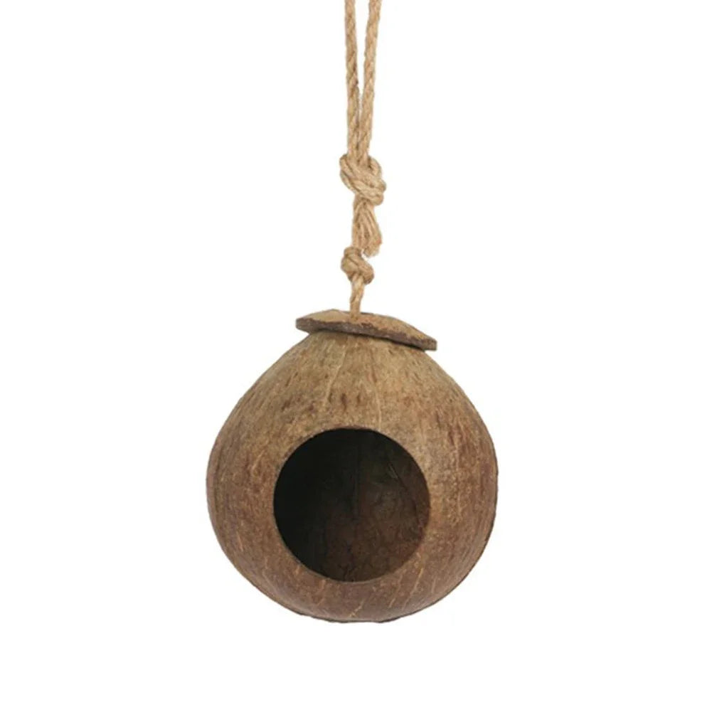 Coconut shell birdhouse hanging on a rope against a white background