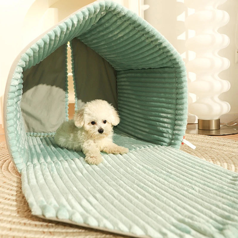 Small white dog lying inside a green pet bed with ribbed texture.