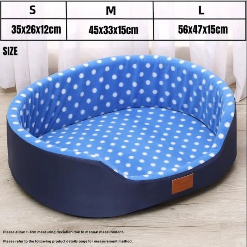 Blue pet bed with white polka dots and size chart on a light wooden floor.