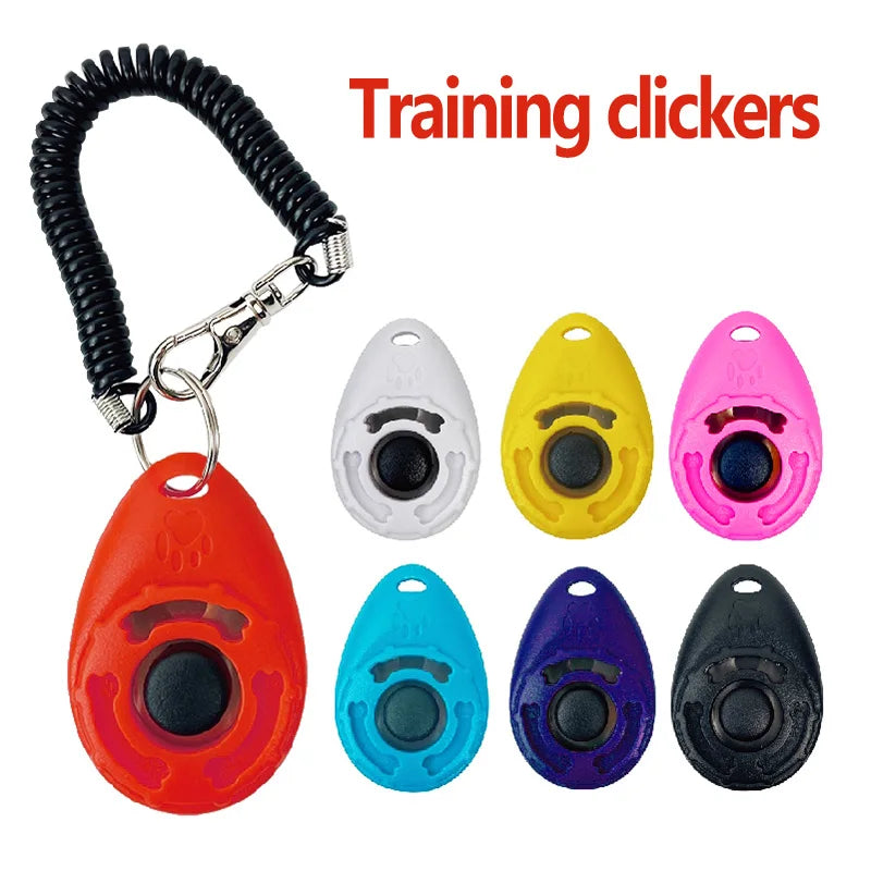 Set of colorful training clickers with a coiled black cord and keychain attachment on a white background.