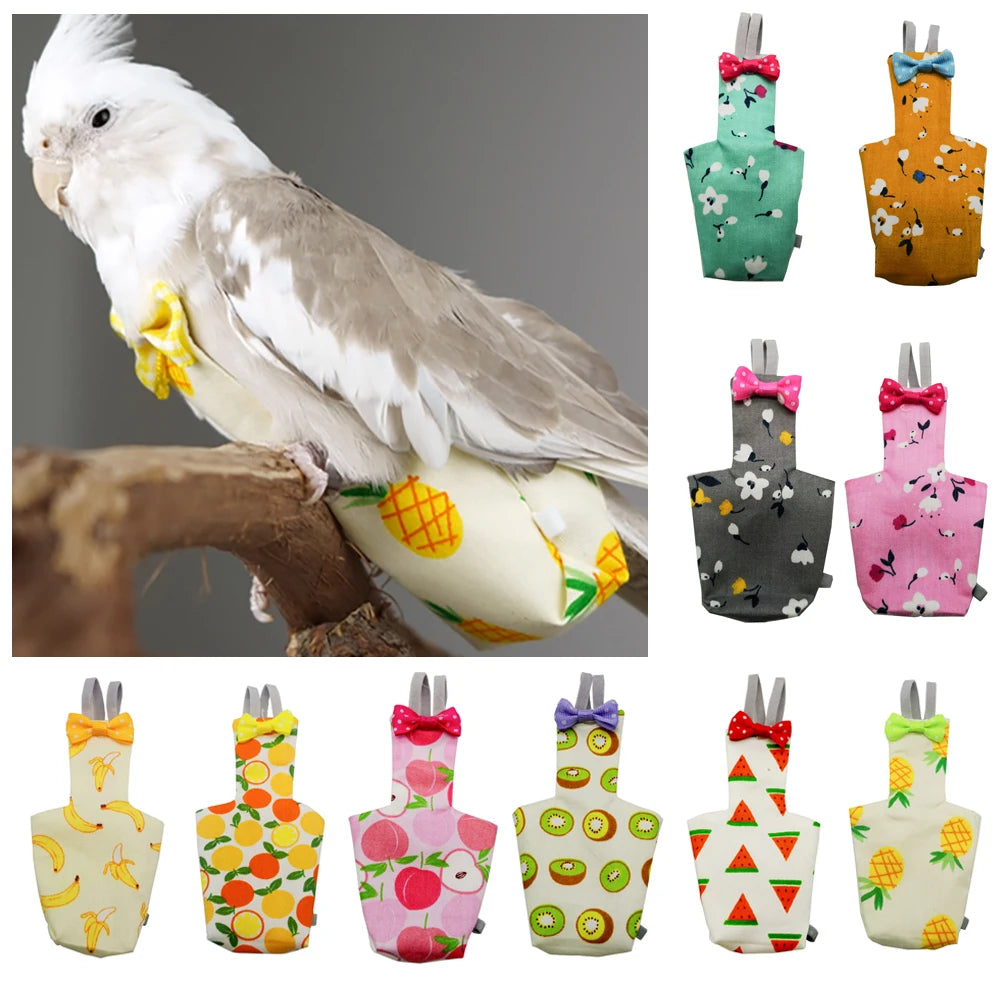 White parrot perched on a branch with colorful bird toys below, including a stack of patterned bird toys.