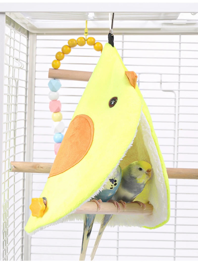 Yellow bird-shaped hammock with two birds inside, hanging from a perch.