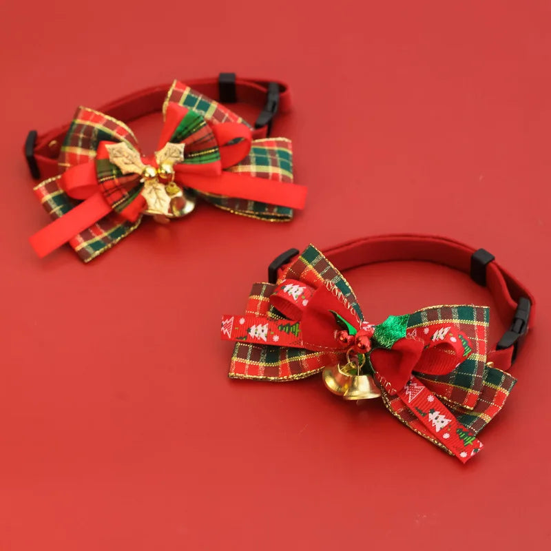 Two red pet collars with decorative Christmas-themed bows and small gold bells, displayed on a solid red background.