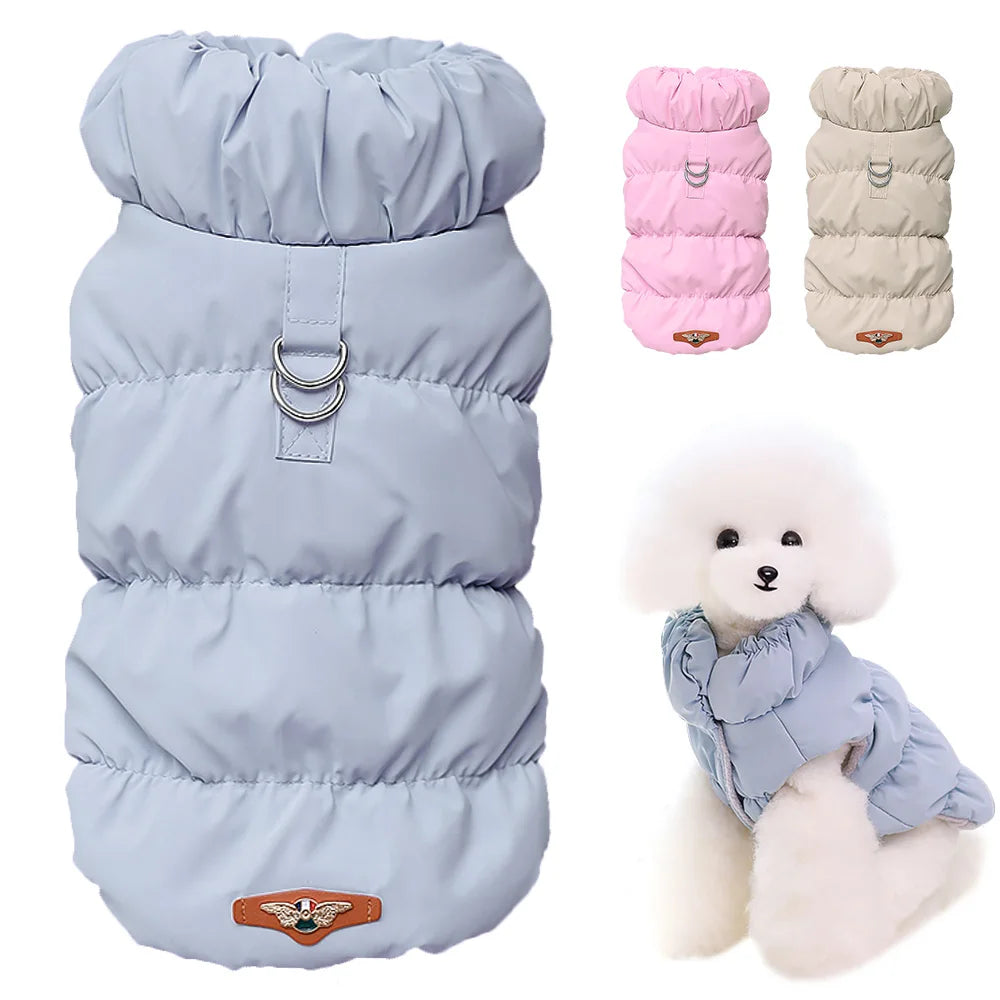 Dog puffer vest in light blue with a small dog model wearing it, and additional vests in pink and beige.