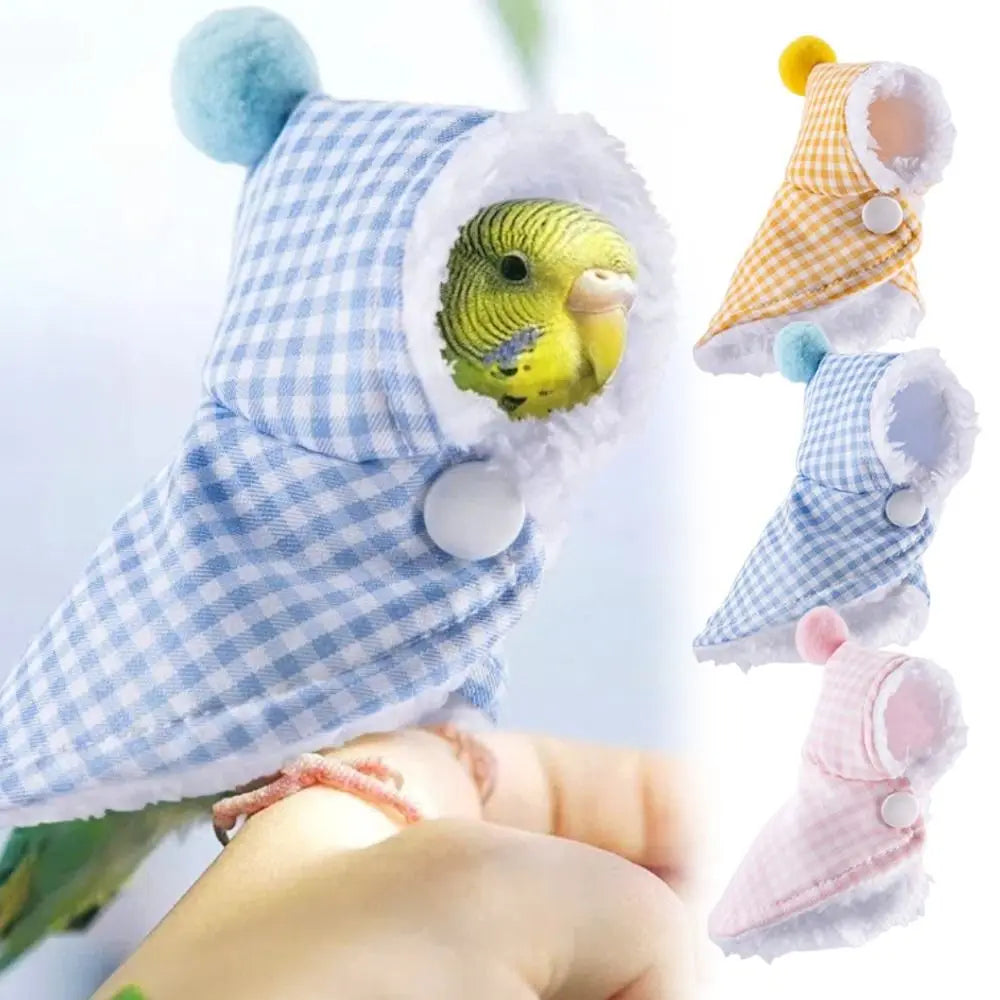 A small green bird wearing a blue-and-white gingham hooded pet bootie with fluffy trim, shown while being held on a person's finger. Three additional color variants appear along the right side: yellow-and-white, light blue-and-white, and pink-and-white.