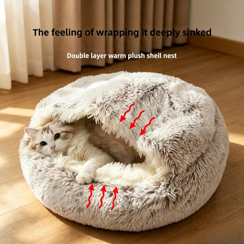 A fluffy round pet bed with a cream and light gray sherpa lining sits on a wooden floor in a sunlit room. A white cat is curled up inside the bed.